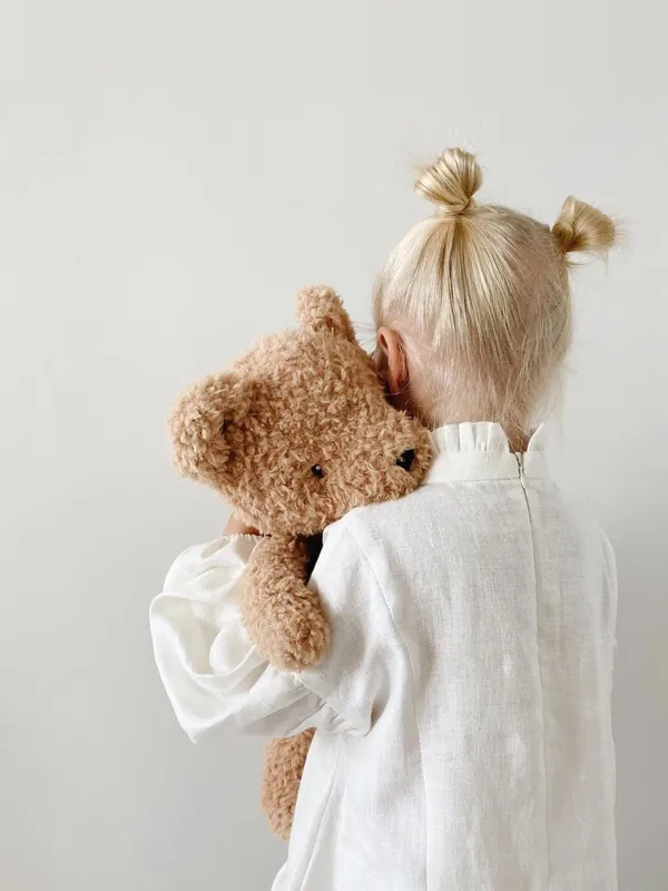 Bambina di spalle che abbraccia un orsetto: psicologa dell’età evolutiva per bambini e adolescenti